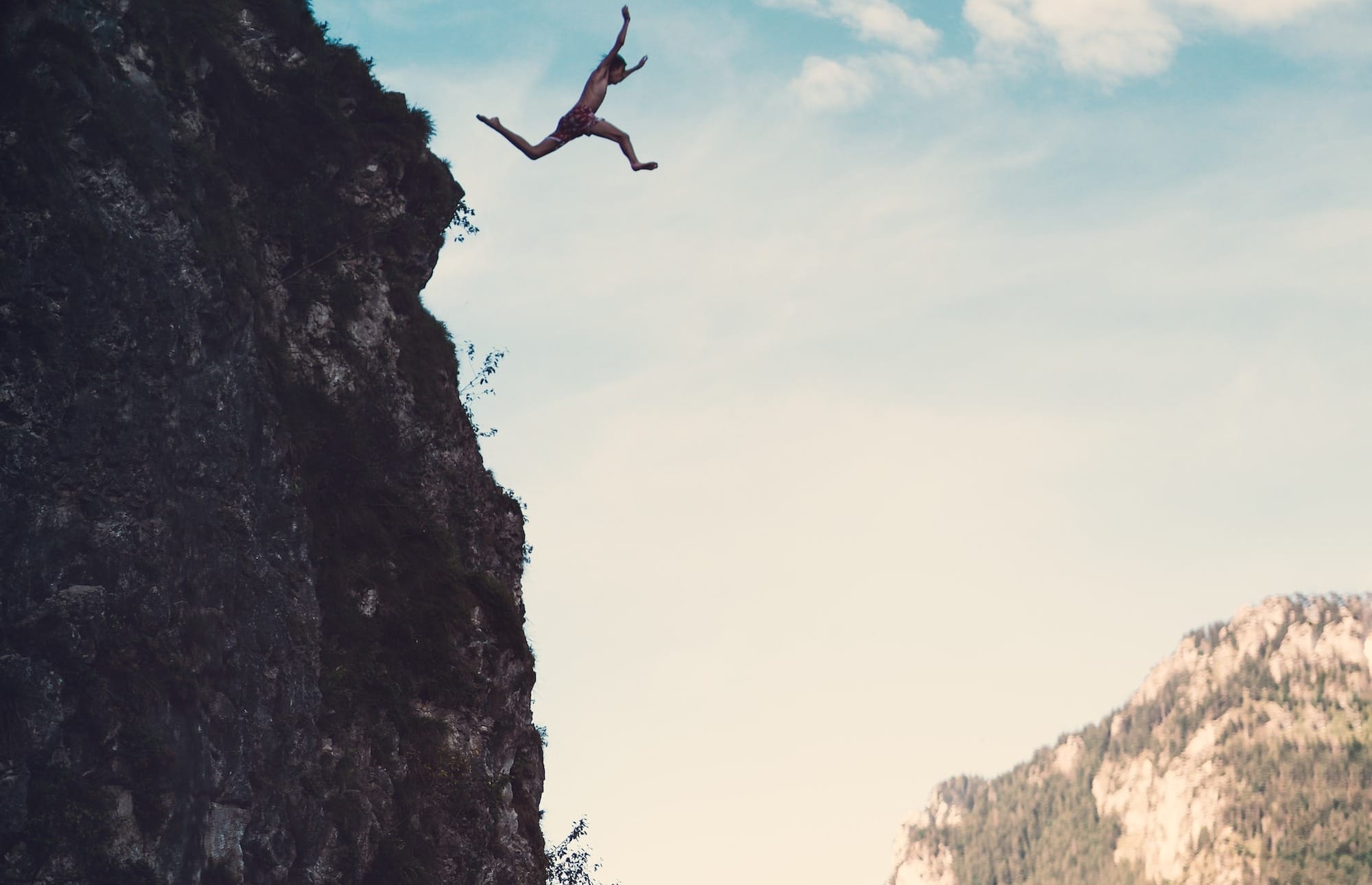 person jumping off cliff